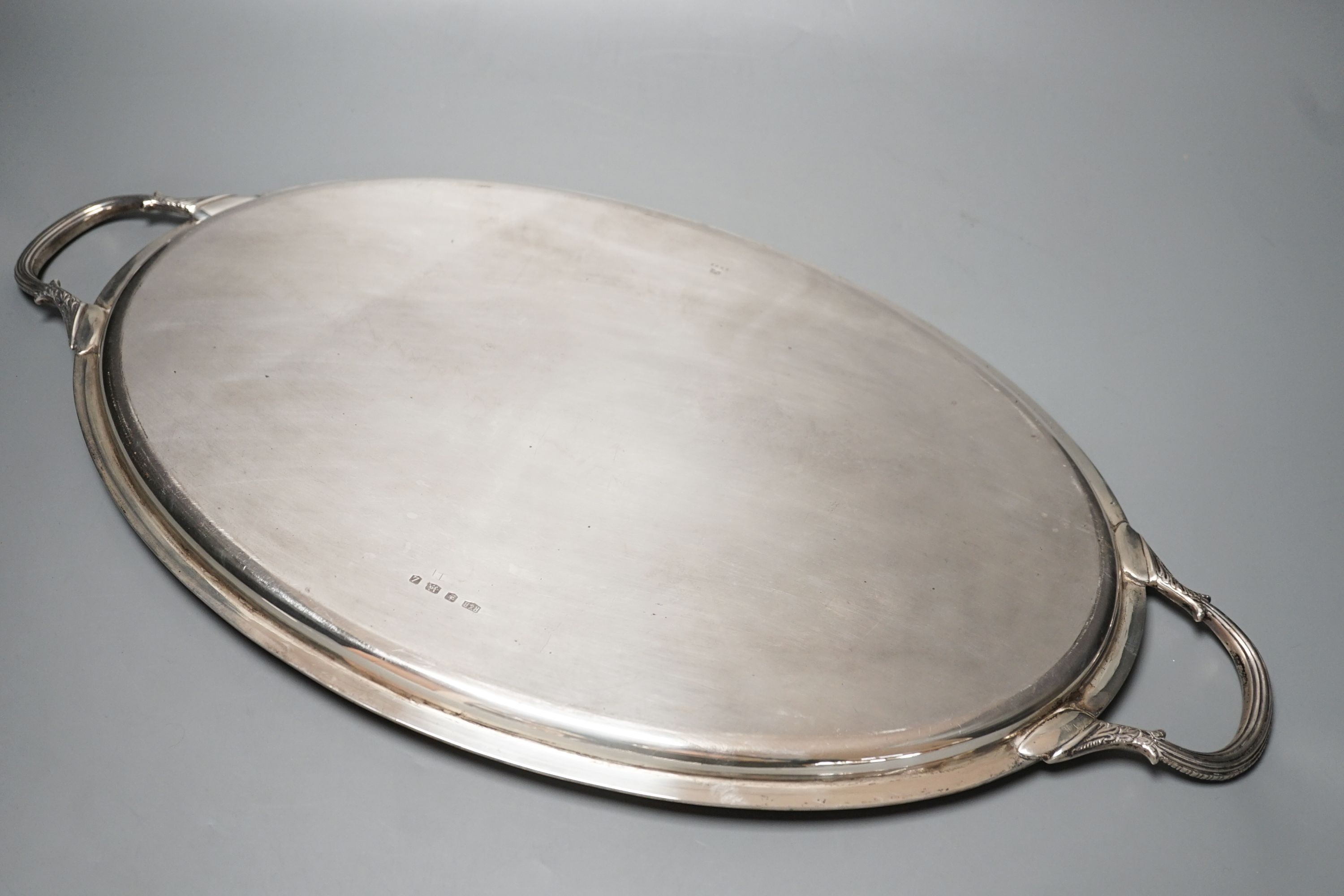 A mid 20th century silver two handled oval tea tray by Roberts & Belk, 56.3cm over handles, 57oz.